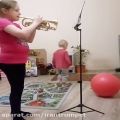 عکس ویدیویی از یک دخترک کورنِت نواز در حال تمرین در منزل