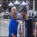 عکس انوشیروان روحانی و همراهی با نوازنده‌ی خیابانی